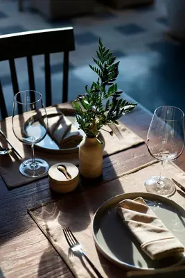 a wooden table with plates and wine glasses on it at Adepa Resort in Canggu