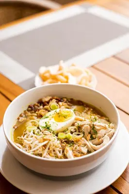 a bowl of soup on a plate on a table at The Daha Luxury Villas in Seminyak