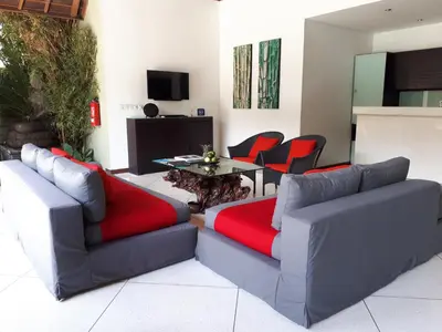 a living room with two couches and a table and chairs at Villa Zanissa in Seminyak