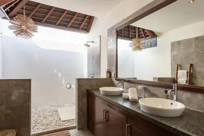 a bathroom with two sinks and a large mirror at Villa Tiga Mangga by Optimum Bali Villas in Seminyak