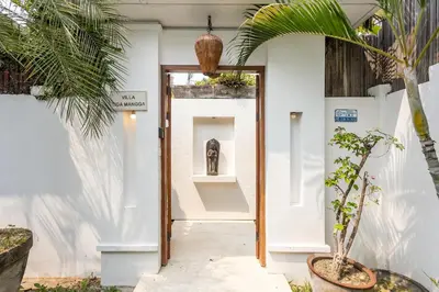 a hallway with a door with a statue in it at Villa Tiga Mangga by Optimum Bali Villas in Seminyak