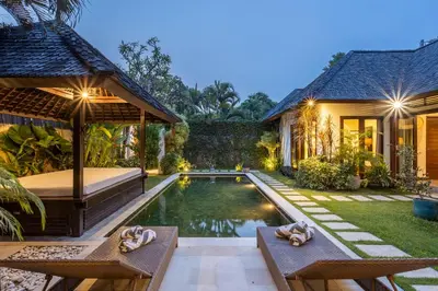 a villa with a swimming pool and a house at Villa Tiga Mangga by Optimum Bali Villas in Seminyak