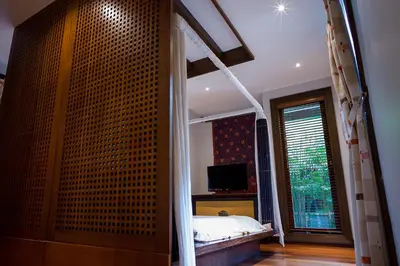 a bedroom with a bed and a television in it at D'Sriwing Villa Gallery in Kuta