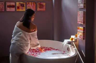 a woman is standing in a bathtub filled with blood at Blue Karma Dijiwa Seminyak in Seminyak