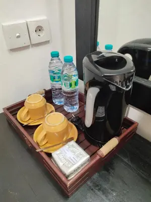 a tray with a coffee maker and two bottles of water at La Walon Hotel in Kuta