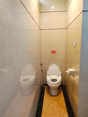 a bathroom with a toilet and a bidet at La Walon Hotel in Kuta