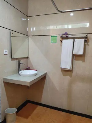 a bathroom with a sink and a mirror and towels at La Walon Hotel in Kuta