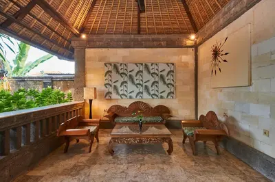 a patio with couches and a table and chairs at Ellies Hotel in Nusa Dua