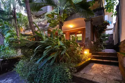 a house with a bunch of plants in front of it at Ellies Hotel in Nusa Dua