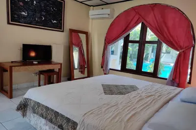 a bedroom with a large bed and a window at Villa Puri Royan Jimbaran in Jimbaran