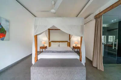 a bedroom with a large bed with a canopy at Villa Paloma - Chic Tropical Garden Villa with Outdoor Pool in Seminyak