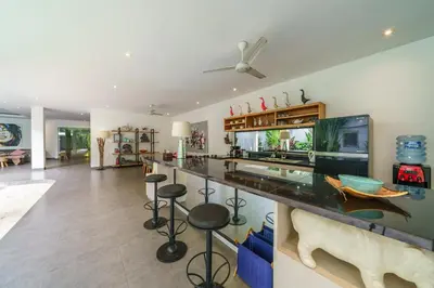 a large living room with a bar with stools at Villa Paloma - Chic Tropical Garden Villa with Outdoor Pool in Seminyak