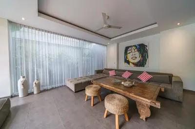 a living room with a couch and a wooden table at Villa Paloma - Chic Tropical Garden Villa with Outdoor Pool in Seminyak