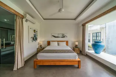 a bedroom with a bed and a large window at Villa Paloma - Chic Tropical Garden Villa with Outdoor Pool in Seminyak