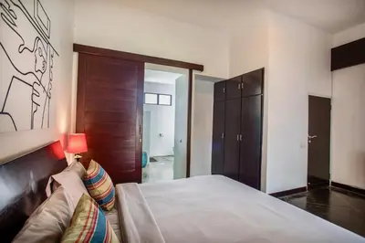 a bedroom with a bed with a lamp and a couch at Villa JULIA | heart of Seminyak | 350m Beach in Seminyak