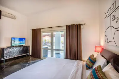 a bedroom with a bed and a sliding glass door at Villa JULIA | heart of Seminyak | 350m Beach in Seminyak