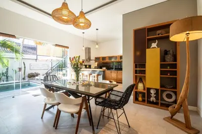 a dining room with a glass table and chairs at Villa Alissa in Seminyak