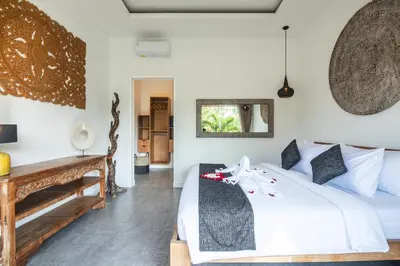a bedroom with a white bed and a desk at Villa Alissa in Seminyak