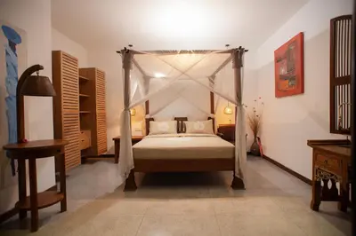 a bedroom with a canopy bed in a room at Villa Zaïna in Seminyak