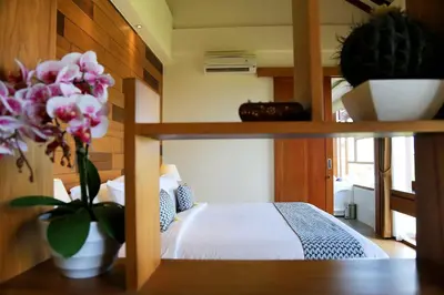 a bedroom with a bed and a vase of flowers at The Wina Villa Seminyak by The Wina Resorts in Seminyak