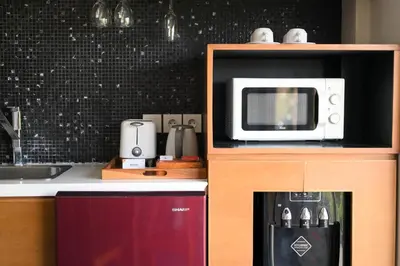 a kitchen with a microwave on top of a counter at The Wina Villa Seminyak by The Wina Resorts in Seminyak