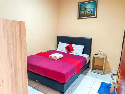 a bedroom with a bed with a red blanket at The Legian 777 in Legian
