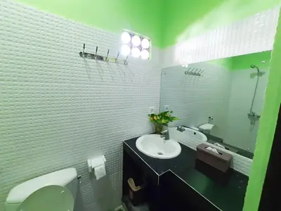 a bathroom with a sink and a toilet and a mirror at The Legian 777 in Legian