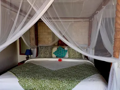 a bedroom with a bed with a canopy at Villa Kora in Seminyak