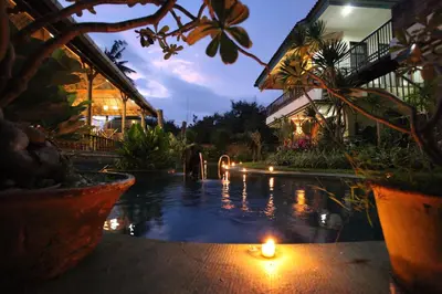 a candle in the water in front of a building at Sanur Seaview Hotel in Sanur