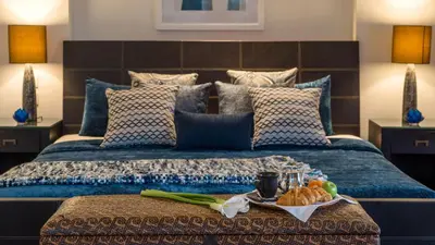 a bedroom with a bed with a tray of food on it at Villa Adenium by Elite Havens in Jimbaran