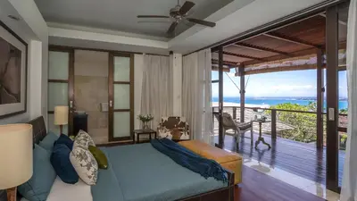 a living room with a couch and a balcony at Villa Adenium by Elite Havens in Jimbaran