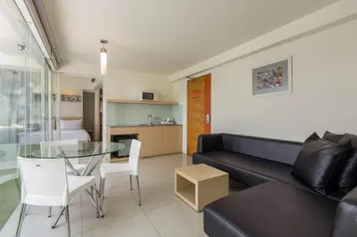 a living room with a couch and a glass table at HARRIS Hotel & Residences Sunset Road in Kuta