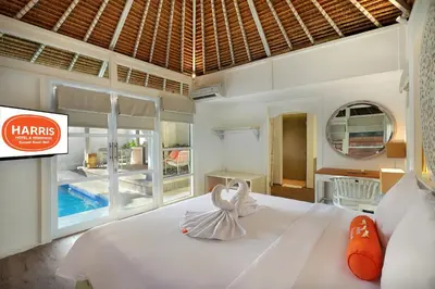 a bedroom with a large white bed and a large window at HARRIS Hotel & Residences Sunset Road in Kuta