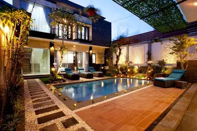 a swimming pool in front of a house at The Nakula Villas in Legian