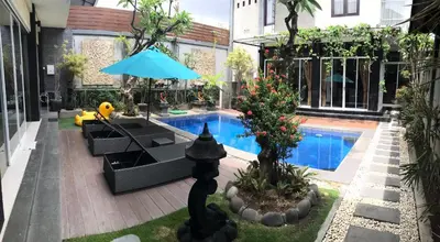 a house with a swimming pool and a blue umbrella at The Nakula Villas in Legian