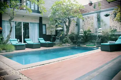 a swimming pool in front of a house at The Nakula Villas in Legian