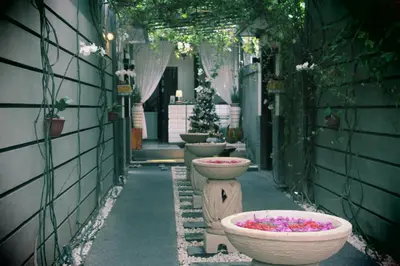 a row of toilets in an alley with flowers in them at The Nakula Villas in Legian