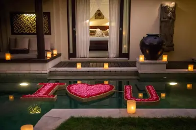 a hotel room with a pool with red heart seats in the water at Villa Air Bali Boutique Resort and Spa in Seminyak