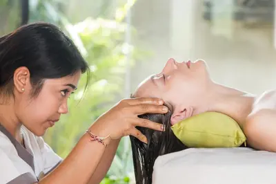 a woman lying on a couch looking at a woman putting her face at Villa Air Bali Boutique Resort and Spa in Seminyak