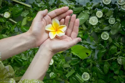 a person holding a flower in their hands at Villa Air Bali Boutique Resort and Spa in Seminyak