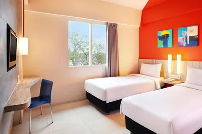 a hotel room with two beds and a tv at Primera Hotel Seminyak in Seminyak
