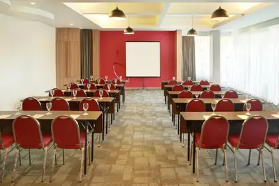 a conference room with tables and chairs and a whiteboard at Primera Hotel Seminyak in Seminyak