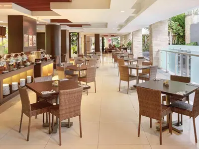 a dining room with tables and chairs in a restaurant at Primera Hotel Seminyak in Seminyak