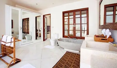 a bathroom with a tub and two sinks and a toilet at Villa Sahaja in Canggu