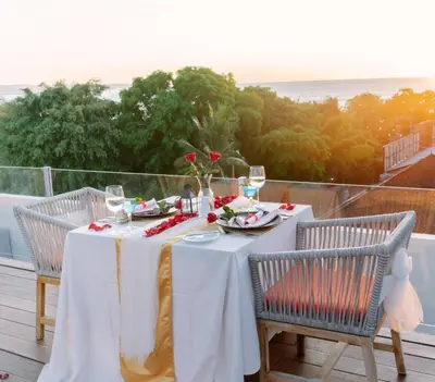 a table with a white table cloth and two chairs at Kuta Beach Hotel in Kuta