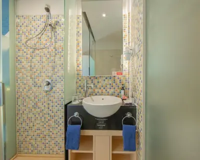 a bathroom with a sink and a mirror at Kuta Beach Hotel in Kuta