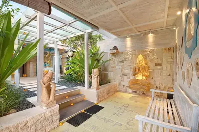 a room with a stone wall with statues on it at Bali Cosy Villas Seminyak in Legian