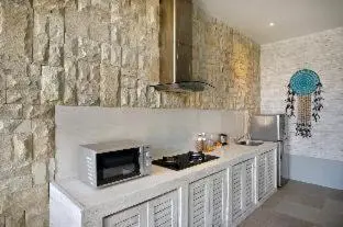 a kitchen with a counter with a microwave at Bali Cosy Villas Seminyak in Legian