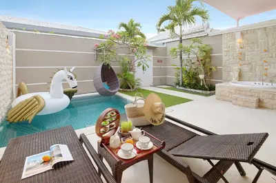a villa with a swimming pool and a patio at Bali Cosy Villas Seminyak in Legian