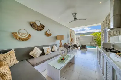 a living room with a couch and a table at Bali Cosy Villas Seminyak in Legian